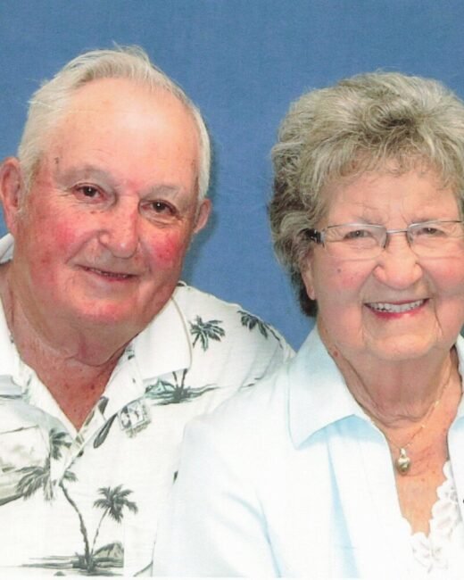 Elderly couple smiling in a portrait.