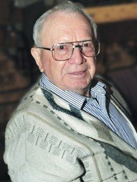 Elderly man wearing glasses and a striped shirt.