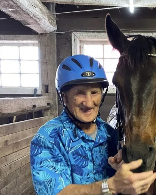 Smiling man wearing helmet with horse