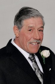 Elderly man in suit with white rose boutonniere.