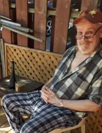Man relaxing on wooden deck with drink