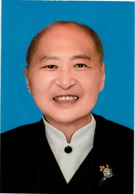 Smiling person in formal attire, blue background