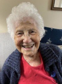 Smiling elderly woman in cozy living room.