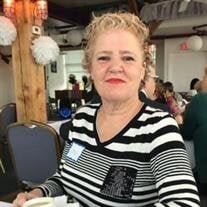 Person smiling at a cafe table with a drink.