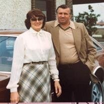 Couple poses in front of vintage car outdoors.