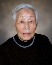 Elderly person with gray hair and black sweater.