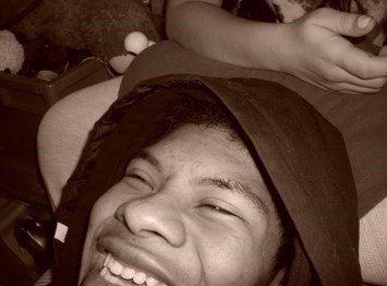 Person laughing while lying down, sepia tone photo.