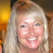 Smiling woman with blonde hair indoors.