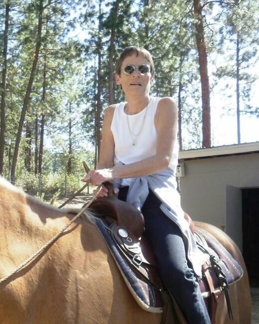 Person riding a horse in wooded area