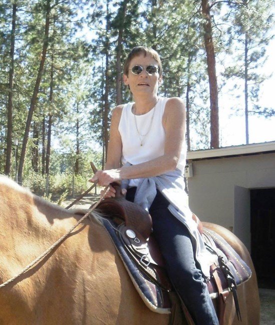 Person riding a horse in wooded area