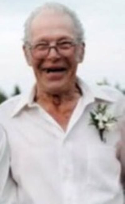 Elderly man smiling in a white shirt
