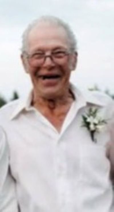 Elderly man smiling in a white shirt