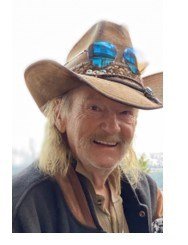 Smiling person wearing cowboy hat with sunglasses