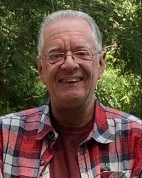 Smiling person in a plaid shirt outdoors