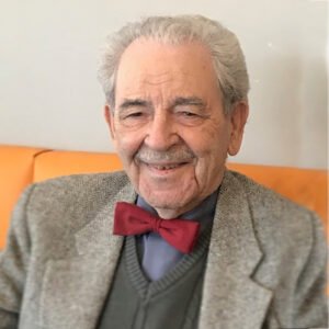 Elderly man with a bow tie, smiling.
