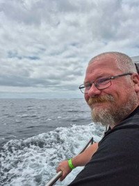 Smiling person on a boat in the ocean.