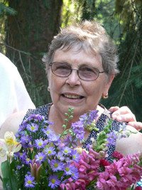 Smiling woman holding colorful flowers outdoors
