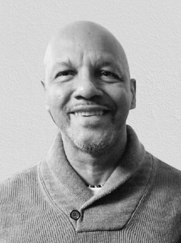 Smiling man in a sweater, black and white portrait.