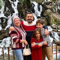Family posing in front of a waterfall.