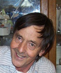 Smiling person indoors near wooden cabinet