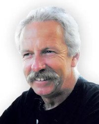 Smiling man with gray hair and mustache.