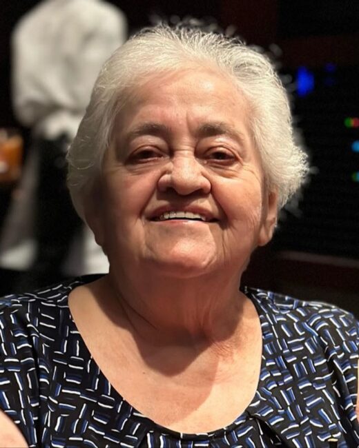 Smiling elderly woman with short white hair.