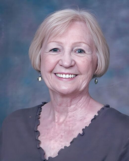 Smiling older woman with short blonde hair.