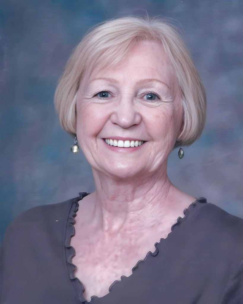 Smiling older woman with short blonde hair.