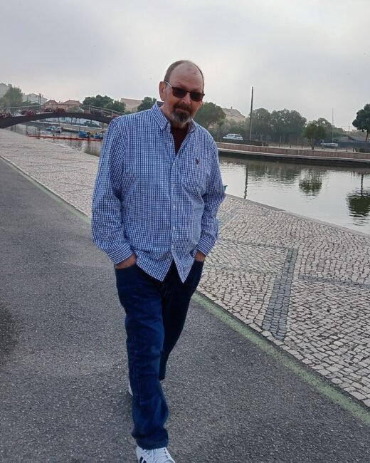 Man walking along a riverside path.