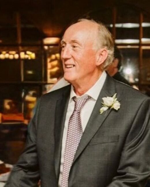 Smiling man in suit with flower boutonniere.