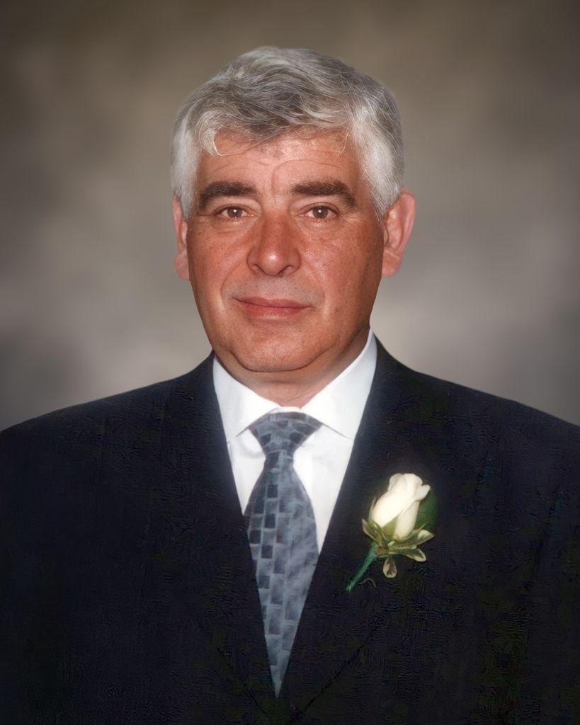 Man in suit with white flower boutonniere.