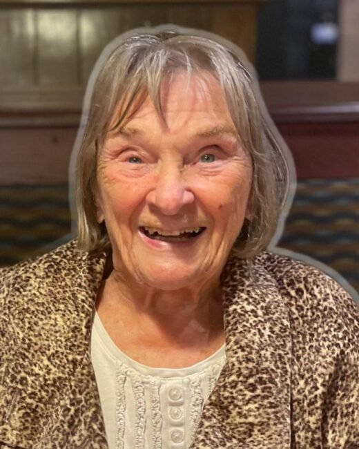 Smiling elderly woman in leopard print coat.