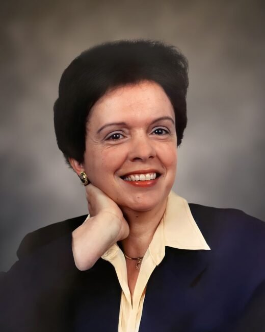 Smiling person posing with hand on chin.