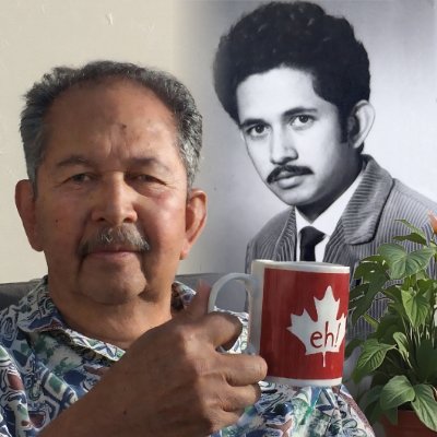 Man holding mug, old photo in background.