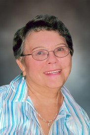 Smiling person wearing glasses and a striped shirt.