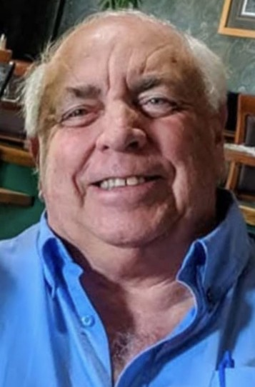 Smiling person in a blue shirt indoors.
