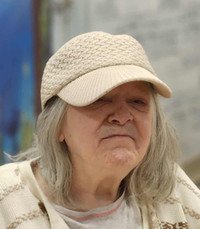 Elderly person wearing a beige hat indoors.