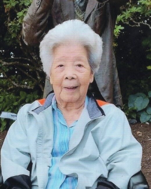 Elderly woman smiling outdoors in a garden