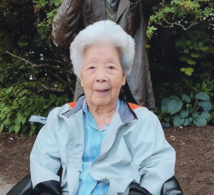 Elderly woman smiling outdoors in a garden