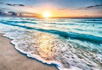 Vibrant ocean sunrise with waves and sandy beach.