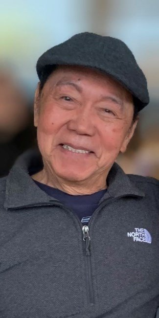 Smiling elderly man in hat and jacket.