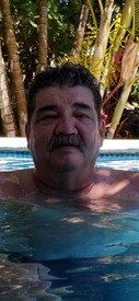 Man relaxing in a swimming pool with trees