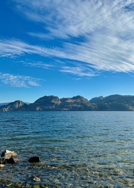 Clear lake with mountains under blue sky