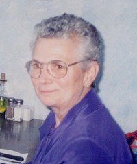 Smiling elderly person sitting at a table.