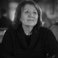 Woman sitting at a table, in thought.