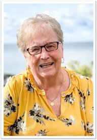 Smiling woman in yellow floral shirt outdoors