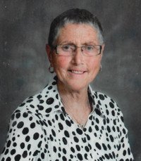 Smiling person in polka dot shirt and glasses.