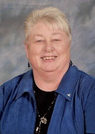 Smiling person with blue shirt and short hair.