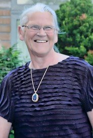 Smiling person wearing a necklace and striped shirt