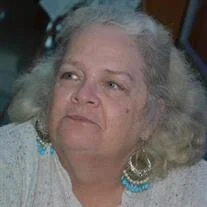 Elderly woman with earrings looks aside pensively.